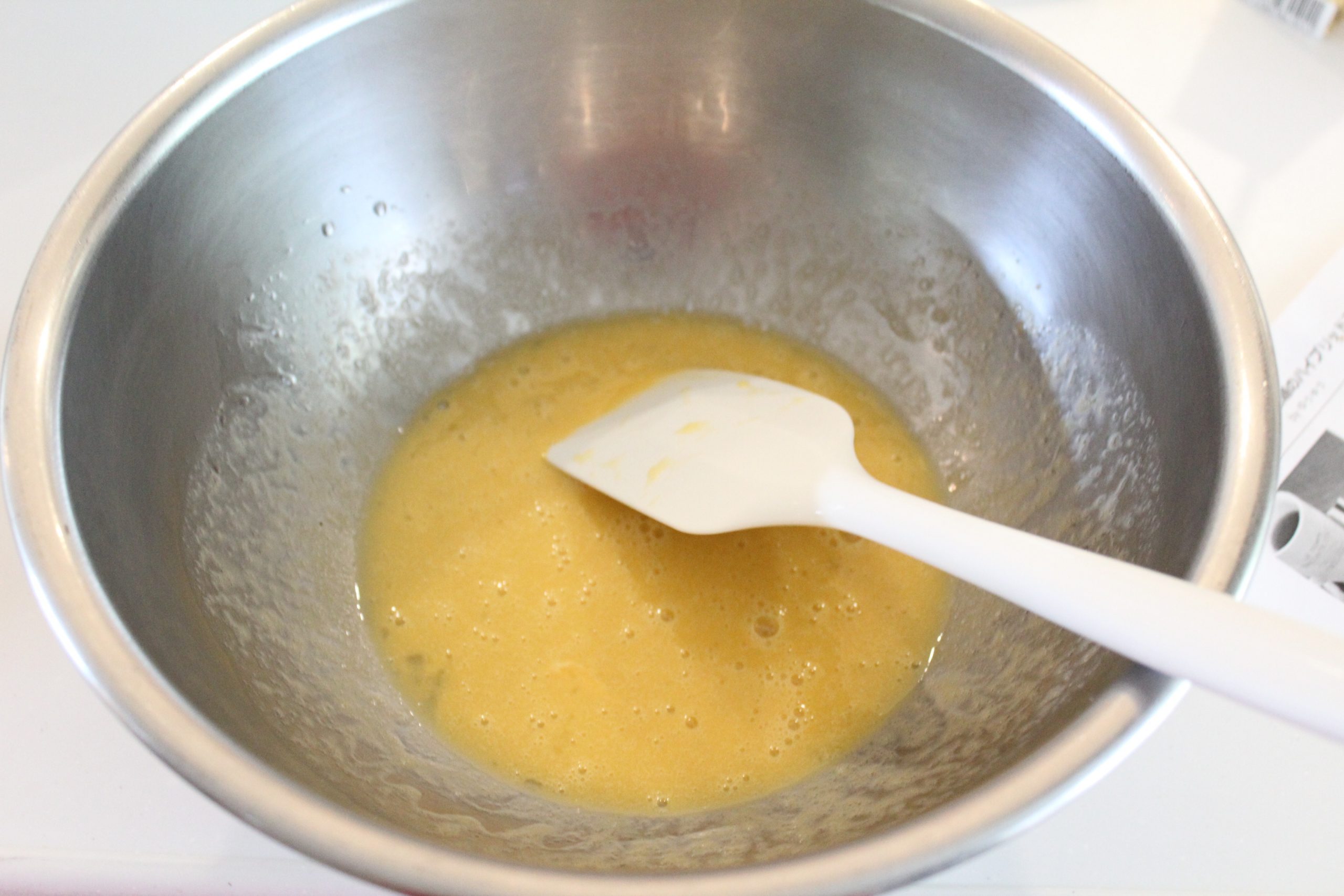 ボウルに卵を割り、サラダ油を加えて、ゴムべラで混ぜる。