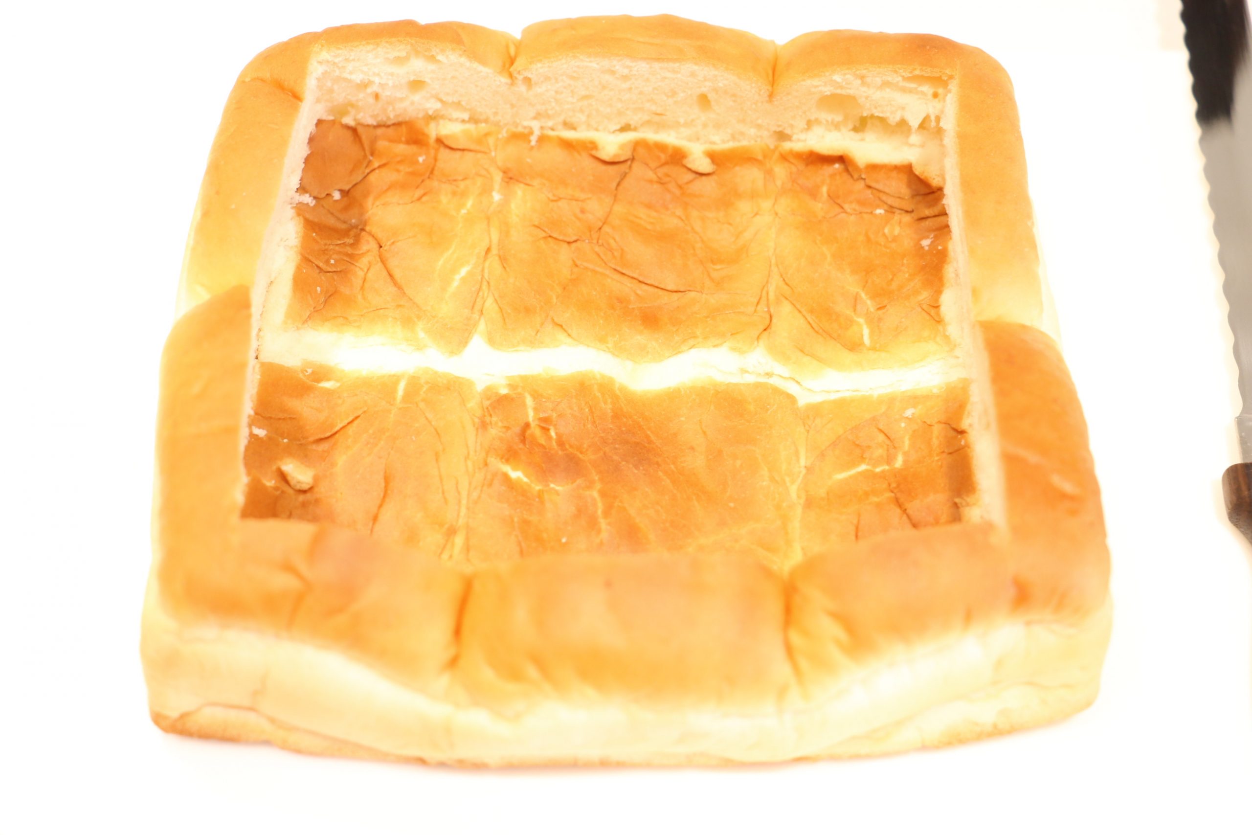 パンは1.5ｃｍ程度端を残し、包丁で切り込みを入れる。（下まで切らないよう注意）
切り込みに沿ってパンを押し込む。