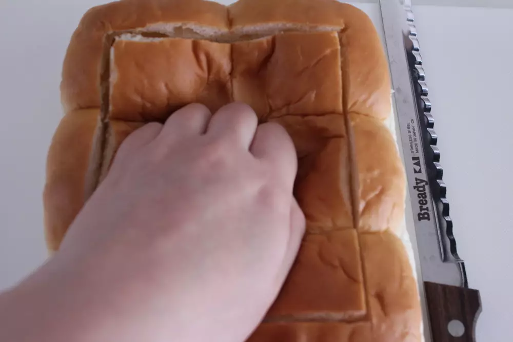 パンは、1.5ｃｍ程度端を残し、包丁で切り込みを入れる。（下まで切らないよう注意）
切り込みに沿ってパンを押し込む。