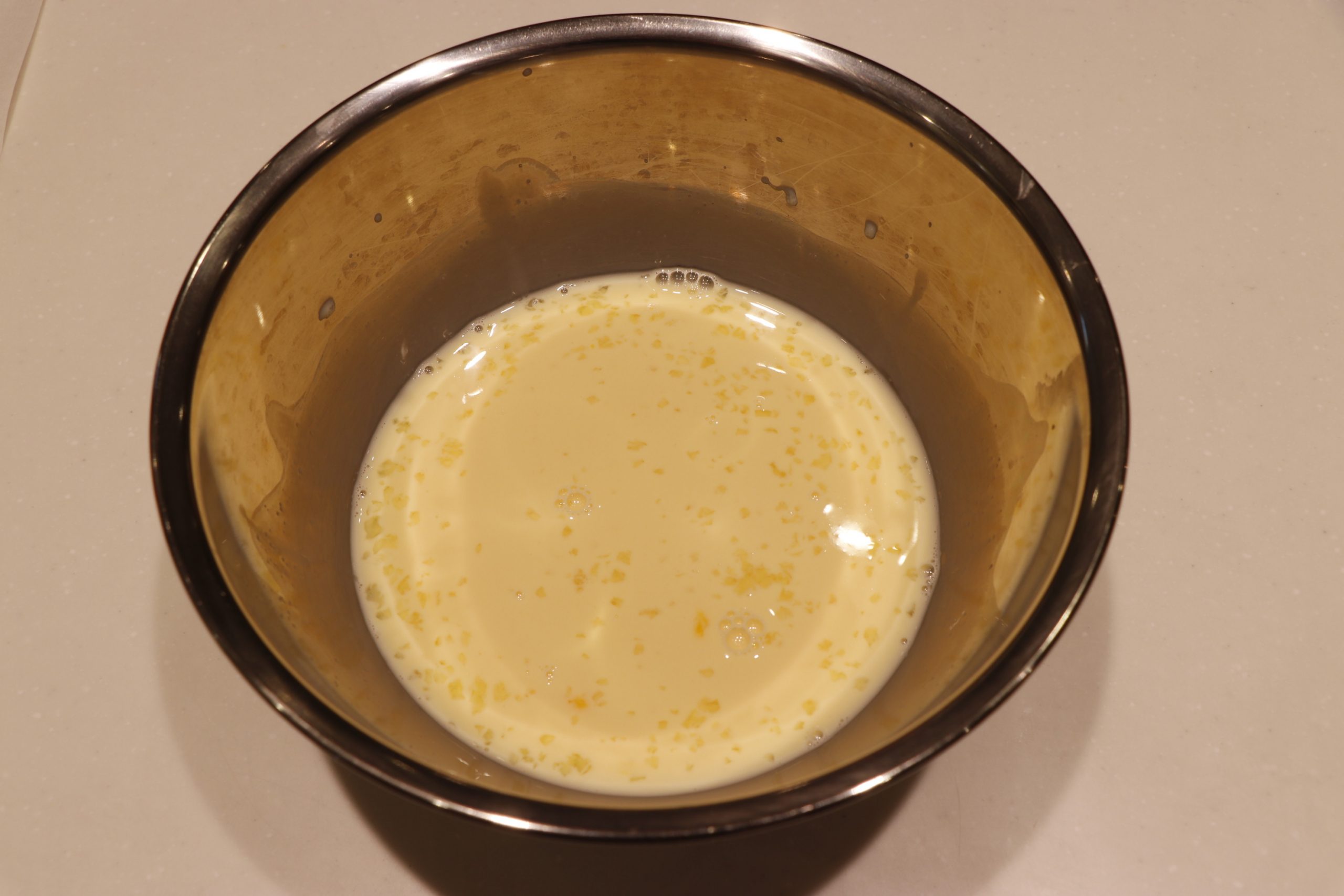 たまごと牛乳と砂糖とバニラエッセンスをボウルに入れて混ぜ合わせる。