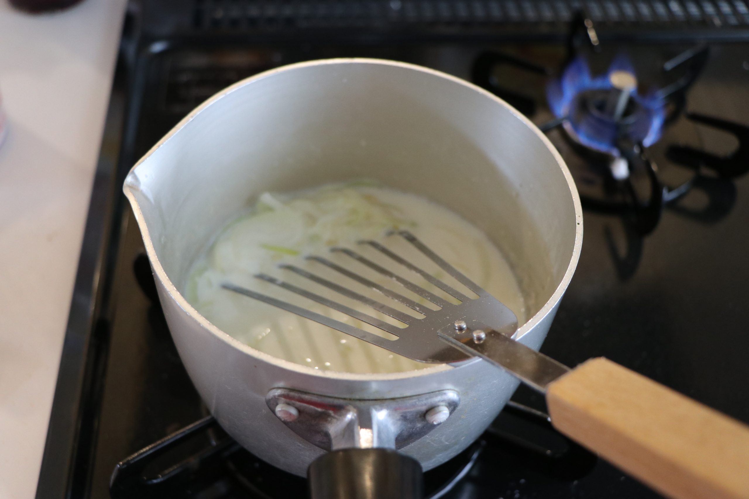 玉ねぎが透き通るまで炒めたら、薄力粉を加えて炒める。
そこに牛乳を少しずつ加えてダマにならないように混ぜる。