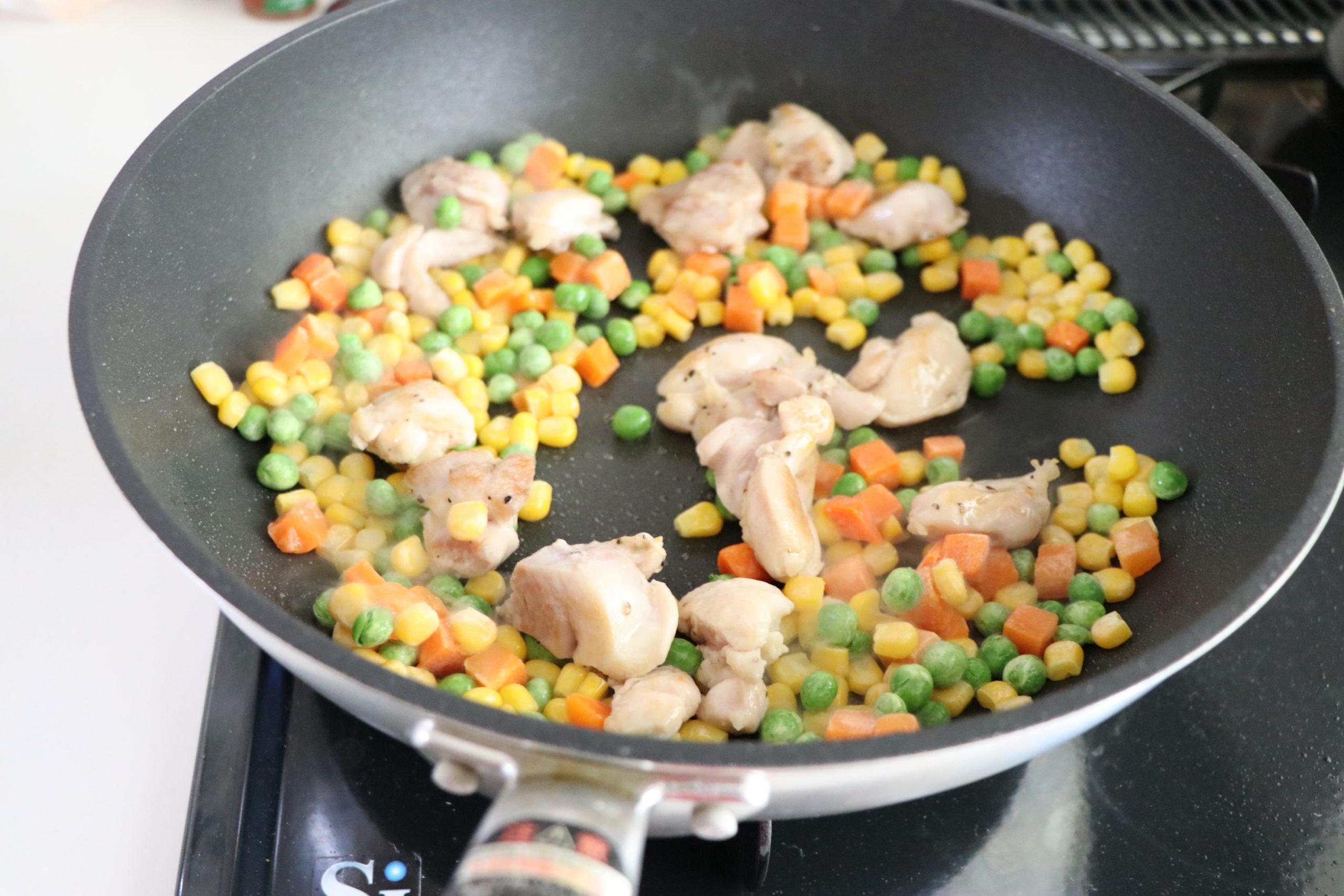 熱したフライパンにオリーブオイルをひき、下味をつけた鶏もも肉を焼く。
火が通ったら、ミックスベジタブルを加えてさっと炒める。
